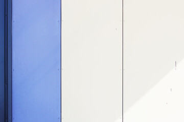 The wall of the house, trimmed with colorful panels, painted in bright colors. Blue and beige