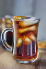 Glass of rum and cola with the ice cubes and slice of orange.