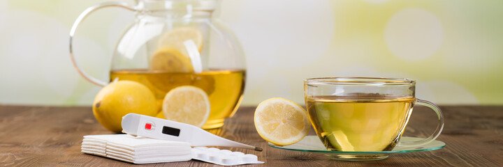tabletten und zitronentee mit fieberthermometer