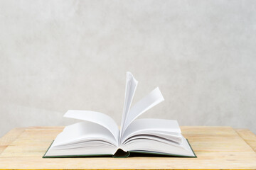 Open book on wooden table.