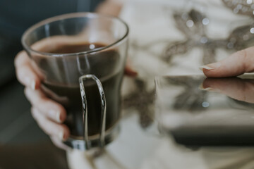 hands of woman with black coffee mug