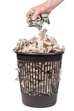 Hand throws crumpled dollars in a trash can with toilet paper isolated on a white background