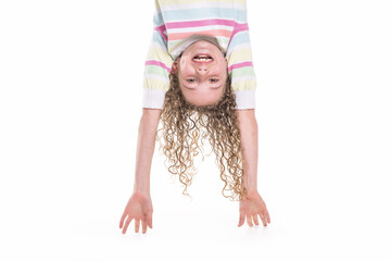 Portrait of happy, smiling, confident 9 years old girl with curly hair, isolated on white upside...