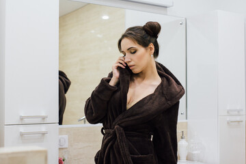 Woman in a brown cosy Bathrobe in the bathroom