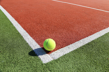 Tenniplatz mit Seitenlinien und gelbem Tennisball, Symbolbild