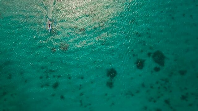 Aerial view of motor boat in sea. Aerial image of motorboat floating in a turquoise blue sea water. Sea landscape with wake of small fast motorboat. Tropical landscape. Philippines, Boracay. 4K video