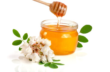 Jar of honey with flowers of acacia isolated on white background