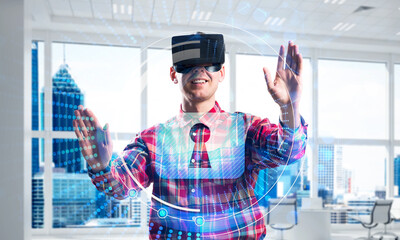 Young man in modern office interior experiencing virtual reality technology