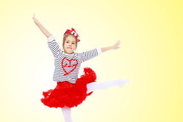 Little girl in a red skirt and bow on her head.
