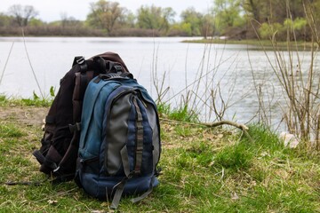 Two touristic backpacks on the riverbank. Hike concept