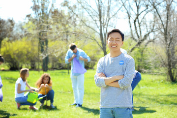 Young Asian volunteer with team outdoors