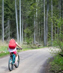 girl with red bag on the forest bike trip