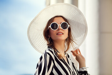 Outdoor close up portrait of young beautiful happy girl posing in street. Model wearing stylish...