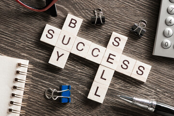 Buy sell success concepts collected in crossword on wooden table - obrazy, fototapety, plakaty