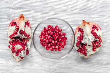 summer dessert with red cut pomegranate on light wooden background top view