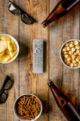 home party with TV watching, snacks and beer on wooden background top view