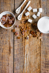 variety of sugar in bowls on wooden table background top view space for text