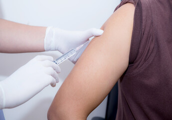 Close-up Of Doctor Injecting Patient With Syringe To Collect Blood