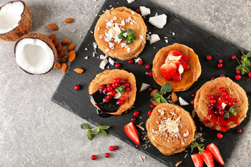Slate plate with stacks of delicious coconut pancakes on textured background