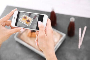 Woman photographing food with smart phone