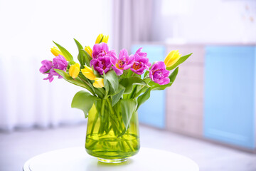 Glass vase with bouquet of beautiful tulips on table