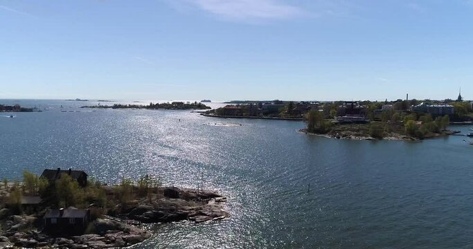 Kaivopuisto, Cinema 4k aerial view of a flight bypassing luoto and ryssansaari and towards brunnsparken, on a sunny summer day, in Helsinki, Finland