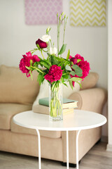 Beautiful peonies and eustoma flowers in vase on light table