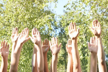 Young people putting hands in air together outdoors. Volunteering concept