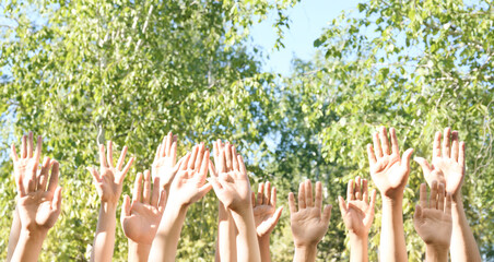 Young people putting hands in air together outdoors. Volunteering concept