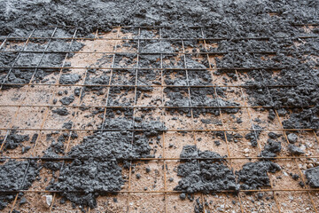 Steel reinforcement mesh on gravel floor with fresh poured concrete