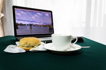 Hot coffee with hamburger on table