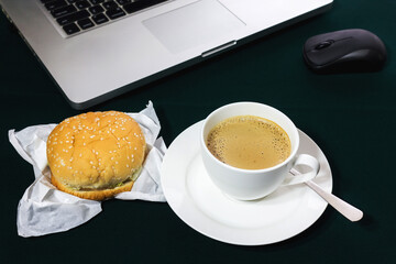 Hot coffee with hamburger on table