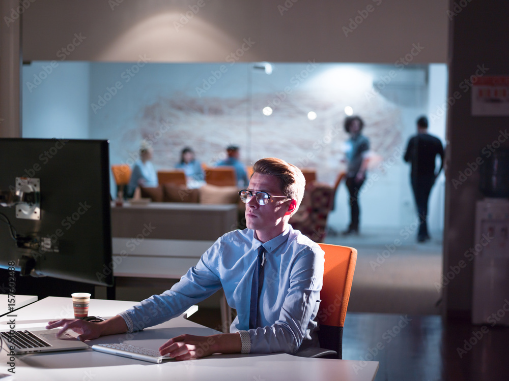 Wall mural man working on computer in dark office