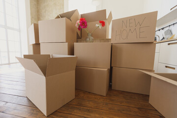New home owners unpacking boxes, big cardboard boxes in new home. Moving to a new apartment concept