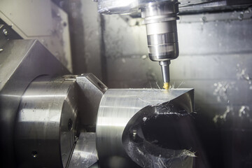 The 5-axis CNC  milling machine  chamfering  the automotive part with the end-mill tool.Hi-technology machining concept.