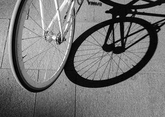 Bike wheel casting shadow on pavement