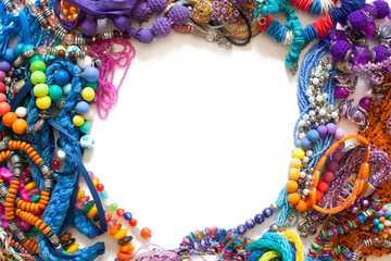 Colorful beads, pliers and bijouterie lie on a white background.