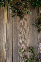 green leaves on a brown wooden background, top view