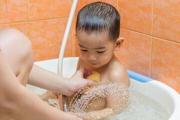 Child bathing with mother in bathroom