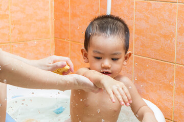 Child bathing with mother in bathroom
