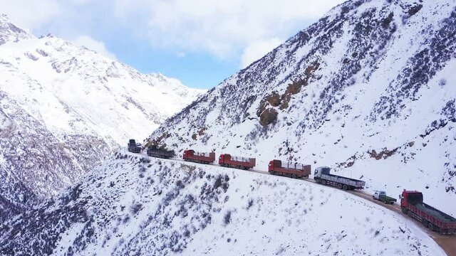 Aerial view of snow covered Chola Pass in Dege country Sichuan China.The row of trucks waiting to pass by the narrow high street.