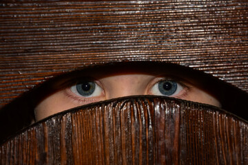 Close-up of the child's blue eyes looking into the slit