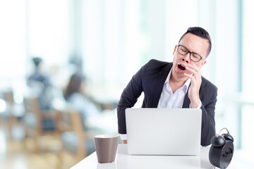 Fototapeta premium Asian businessman yawning between working in office