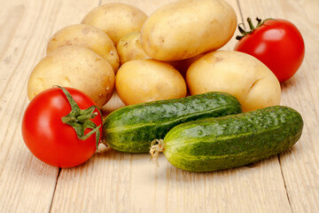 Tomatoes Cucumber potatoes on a white wooden background