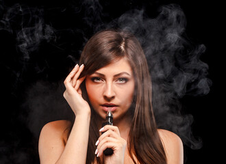 Young woman is vaping. Black background