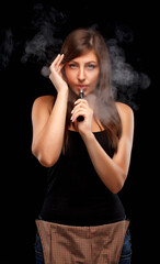 Young woman is vaping. Black background