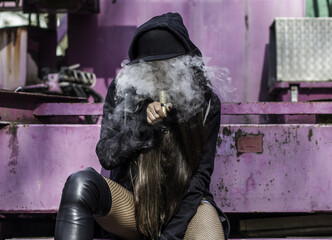 Young sexy woman is vaping.