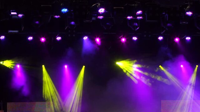 Bright beautiful rays of light on an empty stage before the concert. Stage lights and smoke. 4k