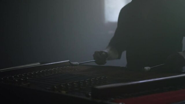Dulcimer string instrument. Close up of male hand hit dulcimer sticks on strings. Traditional folk instrument. Cembalo player playing music. Cymbalo musician instrument