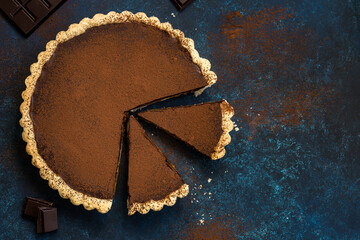 chocolate and caramel tart on dark blue background